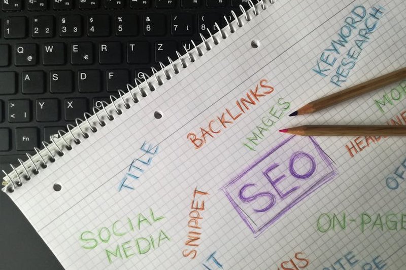 Digital marketer analyzing backlink performance dashboard with traffic and ranking metrics visible on screen